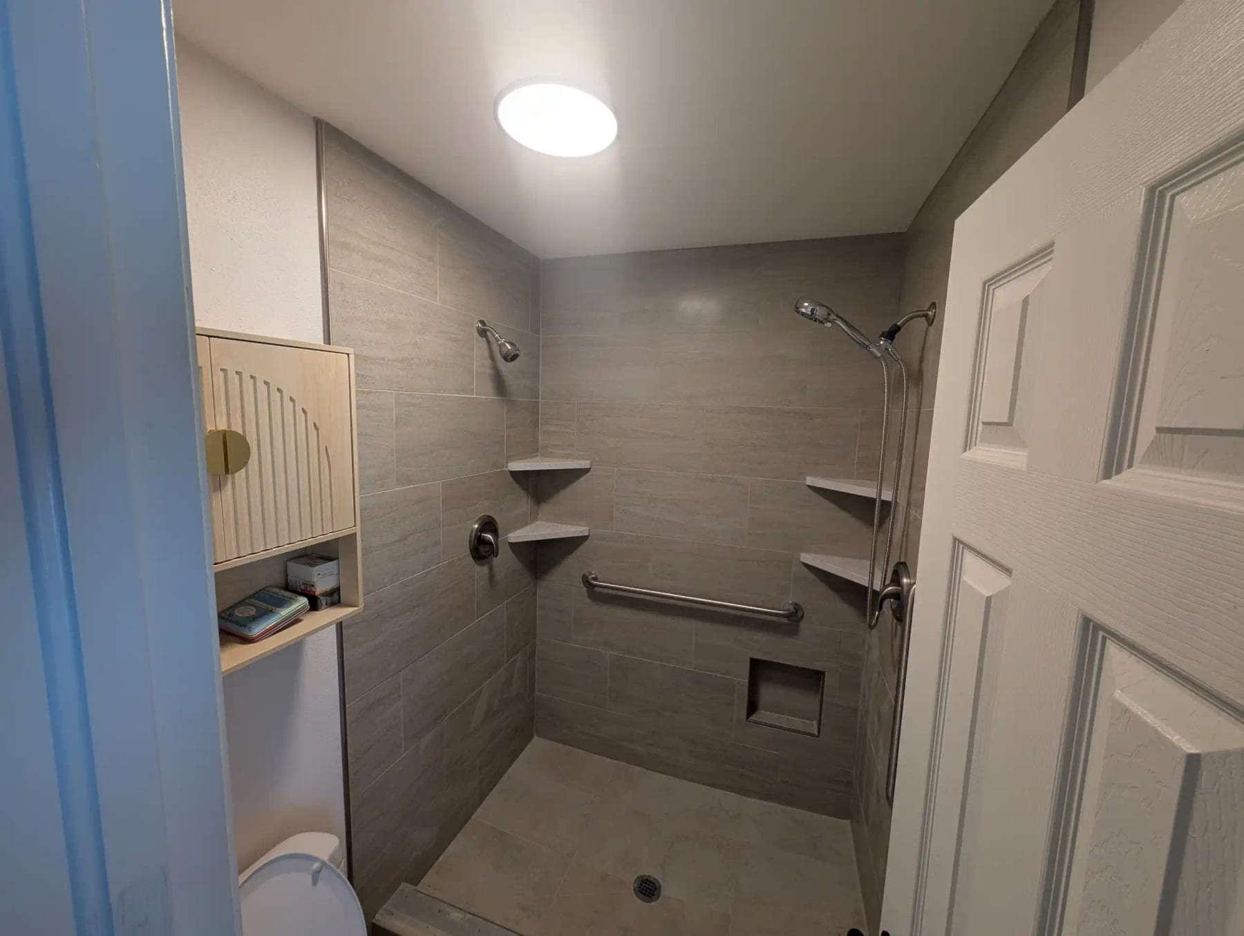 Finished tiled shower with built-in niches and a grab bar